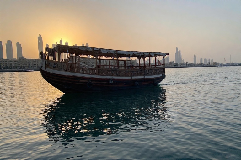 Traditional Dhow Boat Floating on Dubai Creek at Sunset